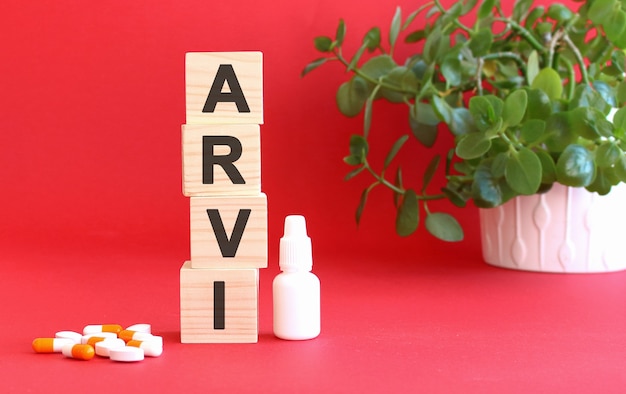Le mot ARVI est composé de cubes en bois sur fond rouge avec des médicaments.
