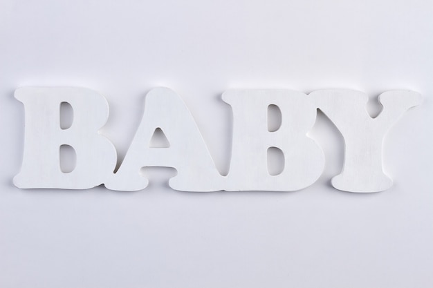 Photo mot bébé de lettres en plastique se bouchent. inscription bébé isolé sur blanc. concept de naissance.