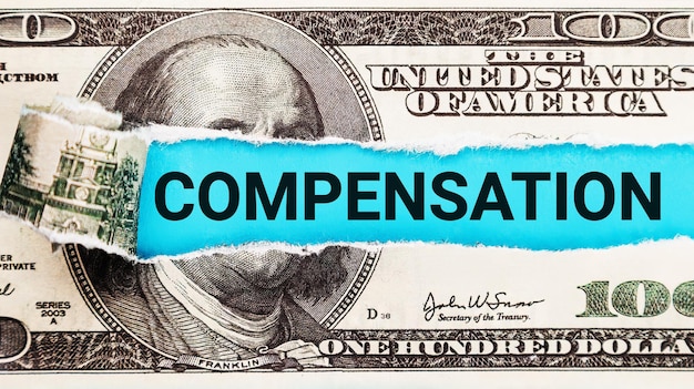 Mot de compensation écrit avec des dollars américains Concept de salaire et de salaire Le mot Compensation sur fond dollar usa Finance et concept d'argent