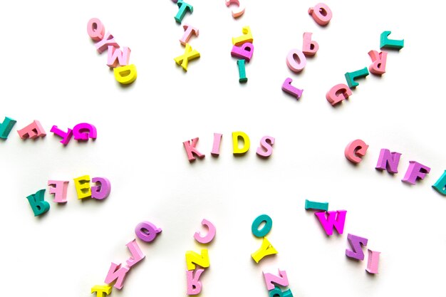 Le mot enfants est composé de lettres multicolores en bois sur fond bleu pour enfants