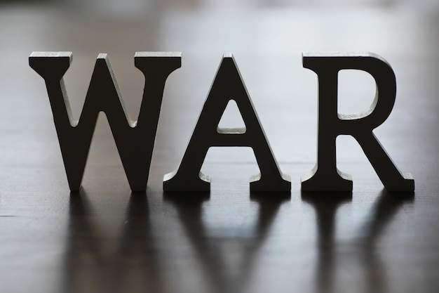 Mot de guerre écrit en lettres de l'alphabet en bois sur fond bleu Le concept d'un terrible pays détruisant la guerre