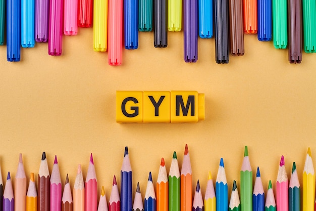 Mot de gym écrit sur des cubes de couleur dans le cadre de crayons colorés