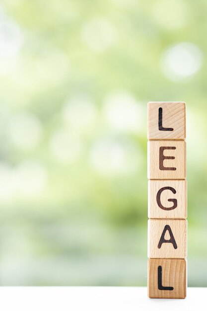 Photo le mot légal est écrit sur des cubes en bois sur un fond d'été vert gros plan d'éléments en bois