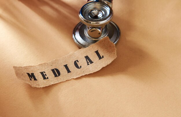 Mot médical écrit sur un morceau de papier déchiré et un stéthoscope