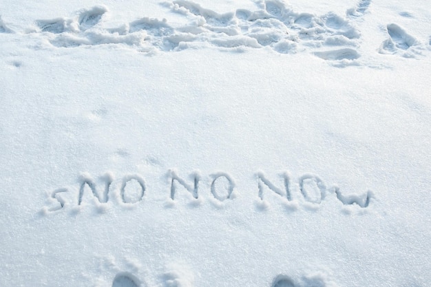 Mot de neige et trois fois en grosses lettres NON écrit sur un banc de neige