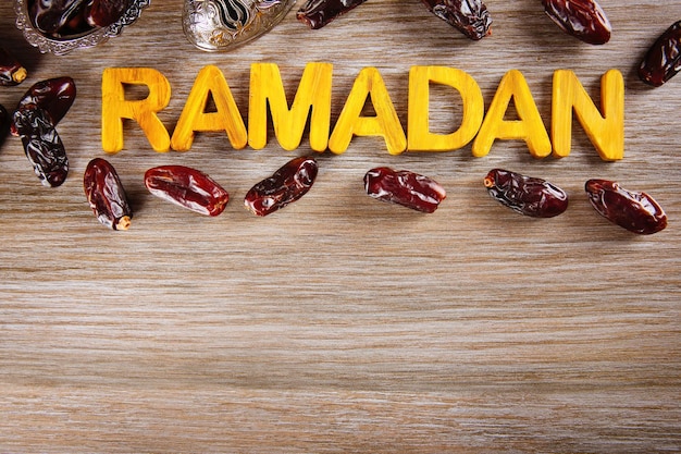 Mot de Ramadan avec des lettres en bois et des dates sèches sur la table