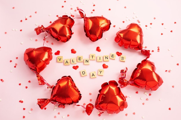 Le mot Saint Valentin des blocs de lettres et des coeurs rouges Foil balloons around.