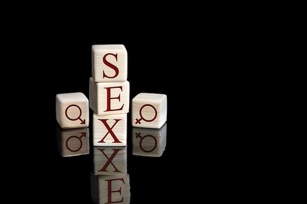 Mot Sexe écrit Par Des Cubes En Bois Avec Des Lettres Sur Fond Réfléchissant Noir