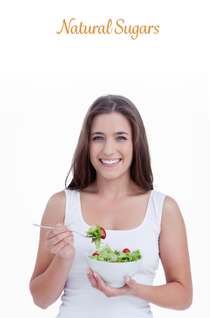 Le mot sucres naturels contre une femme souriante mangeant une salade
