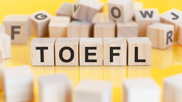 Le mot toefl est écrit sur des blocs de structure en cubes en bois sur un fond clair concept financier mise au point sélective toefl court pour le test d'anglais comme langue étrangère