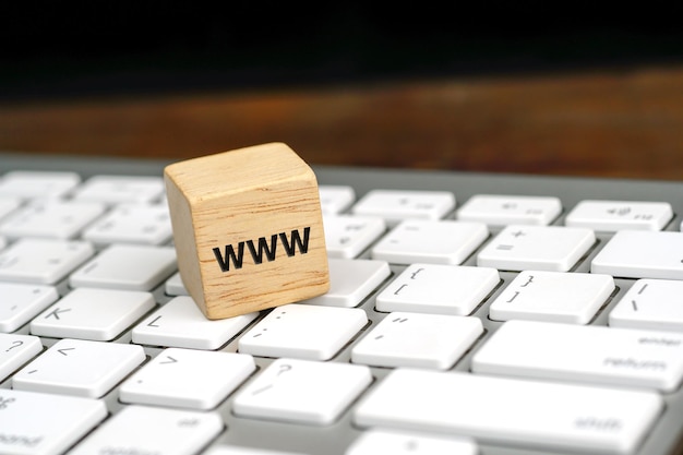 mot www, world wide web écrit sur une cale en bois sur un clavier d'ordinateur blanc. Communication en ligne