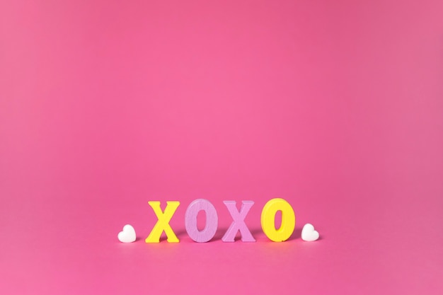 Mot XOXO avec coeur blanc sur rose