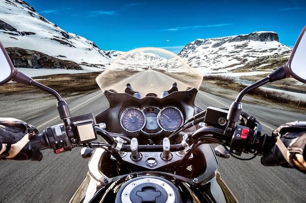 Un motard conduisant une moto roule le long de la route goudronnée. Vue à la première personne.