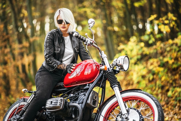 Motard femme jolie blonde avec une moto rouge