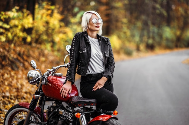 Motard femme jolie blonde avec une moto rouge