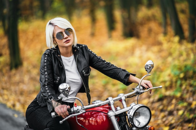 Photo motard femme jolie blonde avec une moto rouge