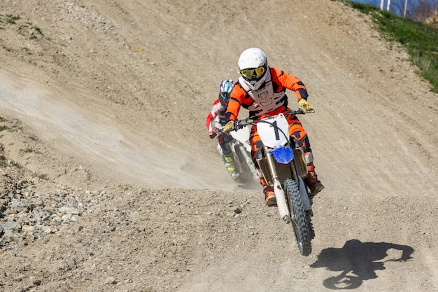 Le motard professionnel de motocross conduit à travers la fumée et la brume sur la piste de Dirt Road.