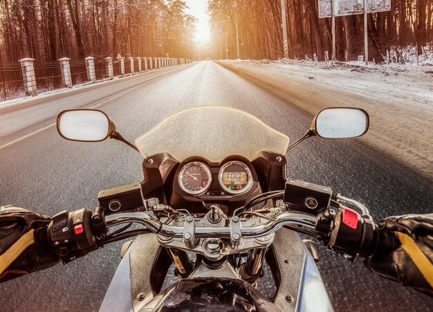 Le motard roule sur une route glissante en hiver. Vue à la première personne.