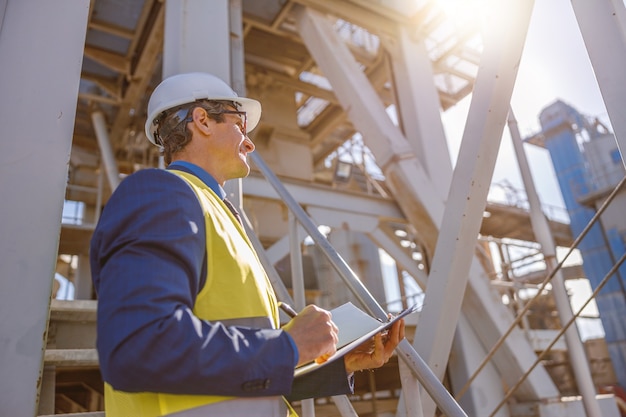 Moteur mâle avec des documents debout à l'extérieur de l'usine