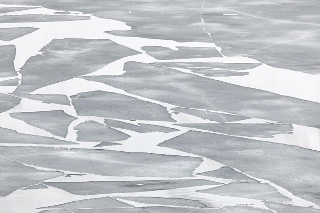 Photo motif abstrait de plaques de glace flottantes sur le lac avec le reflet d'une montagne enneigée