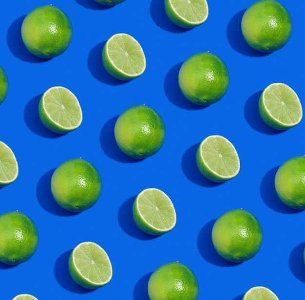 Motif composé de citrons verts entiers et coupés sur fond bleu Composition de fruits lumineux
