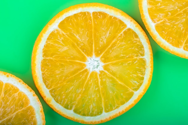 Motif d'été tropical lumineux avec gros plan de fruits orange sur fond vert.