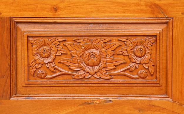 Motif de fleur sculpté sur fond de bois, style thaï