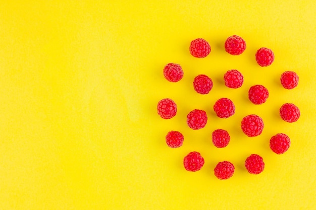 Photo motif de framboises sur fond jaune diète colorée et concept d'alimentation saine vue supérieure