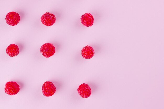 Un motif de framboises sur fond rose Un régime alimentaire coloré et un concept d'alimentation saine