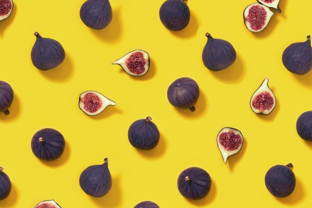 Motif de fruits figues fraîches colorées sur fond jaune vif, figue entière et tranchée.