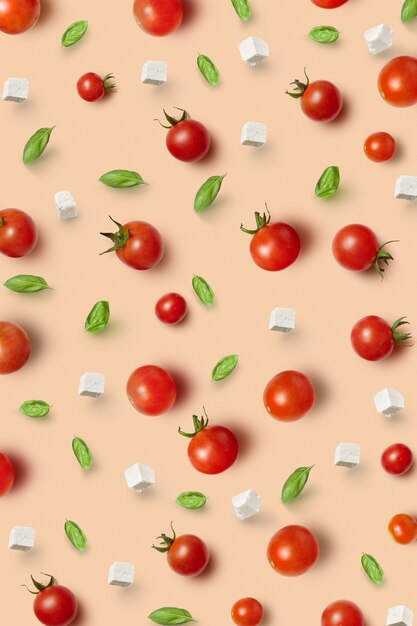 Motif de légumes à partir de tomates mûres saines biologiques fraîchement cueillies, cerises, feuilles de basilic et cubes de fromage