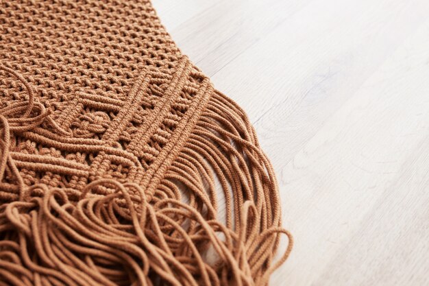 Motif macramé fait main se bouchent. Tressage en macramé et fils de coton sur table en bois. Passe-temps féminin. Concept de décoration naturelle de bricolage à tricoter moderne et respectueux de l'environnement à l'intérieur. Espace de copie