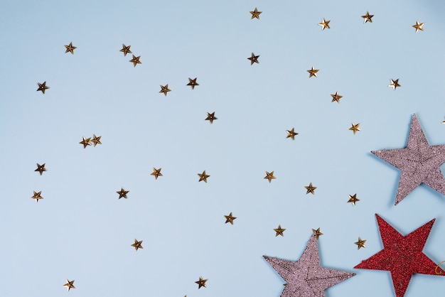 Motif de Noël composé d'étoiles dorées, argentées et rouges sur bleu