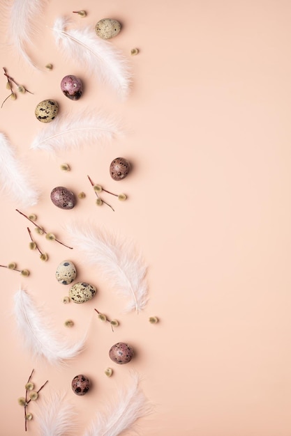 Motif de printemps de Pâques sur un saule de plumes d'oeufs de caille de fond rose