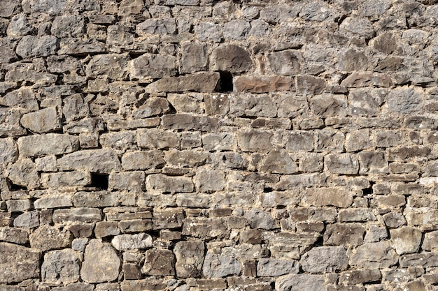 Le motif de texture Le vieux mur brun de fond en pierre naturelle