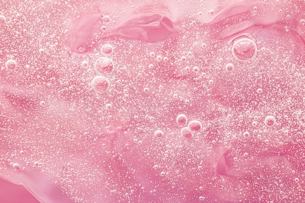 Motif de tourbillon d'éclaboussures de peinture de fond liquide rose abstrait et gouttes d'eau gel de beauté et texture cosmétique art magique contemporain et science comme design flatlay de luxe