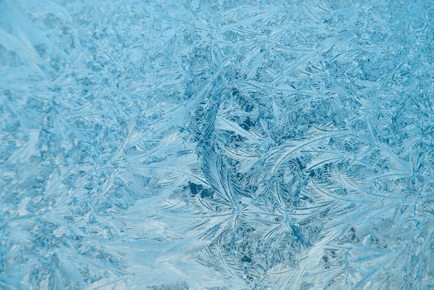 Motifs givrés sur fond de Noël en verre Glace bleue sur la fenêtre d'hiver