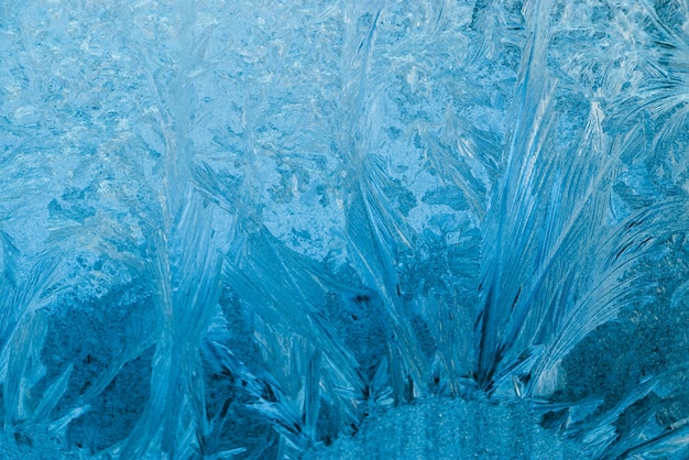 Motifs givrés sur fond de Noël en verre Glace bleue sur la fenêtre d'hiver
