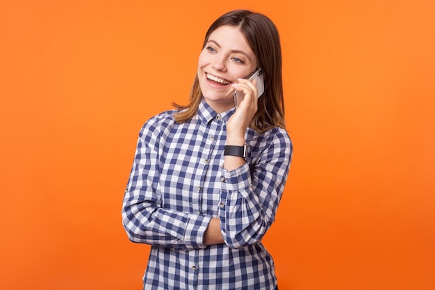 Émotionnelle jeune femme brune sur fond orange