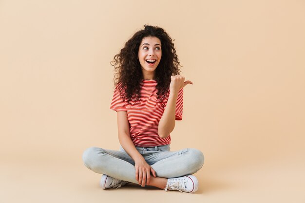 Émotionnelle jeune femme isolée sur mur beige