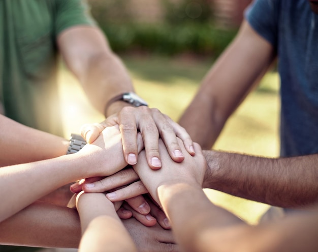 Motivation en plein air et rapprochement des gens avec les mains ensemble pour le travail d'équipe, le soutien et la réalisation Amis, les bras et la confiance avec la pile dans le parc pour la collaboration, la solidarité et l'accord dans l'unité