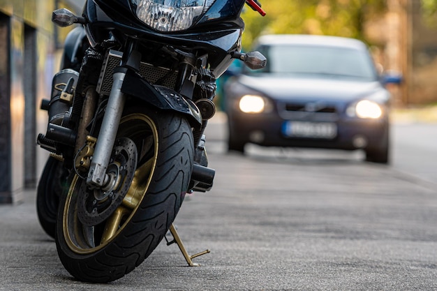 Une moto garée sur le trottoir avec une rue de la ville floue avec des voitures en arrière-plan