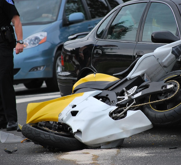 Une moto noire jaune cassée après un accident.