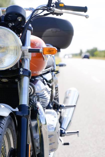 Moto orange et vintage garée sur route