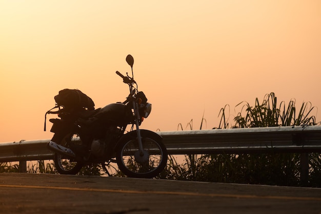 Moto rétro noire avec sac à dos garée à l'extérieur