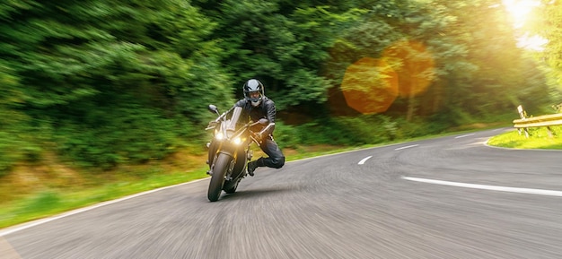 moto sur la route forestière à cheval. s'amuser à conduire la route vide lors d'un voyage en moto. copyspace pour votre texte individuel.