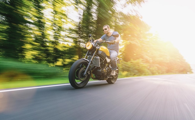 Moto scrambler moderne sur la route à moto au coucher du soleil copyspace pour votre texte individuel