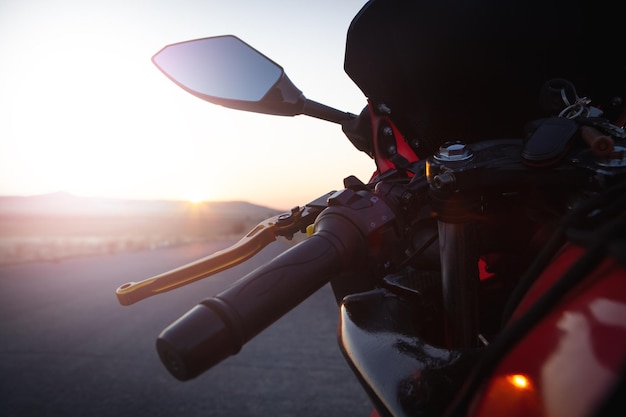 Photo la moto se tient sur la route au coucher du soleil