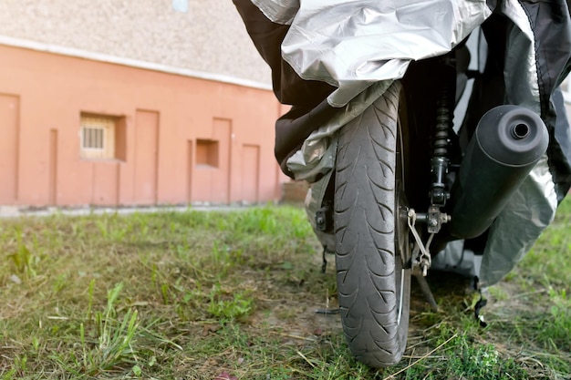 Moto sous housse de protection dans la rue