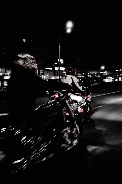 Photo un motocycliste qui roule dans la ville la nuit motion blur